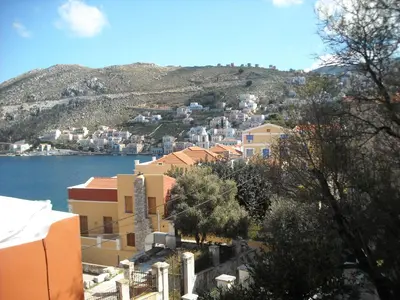 a group of buildings on a hill next to a body of water at Dorian Hotel in Symi