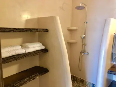 a bathroom with a bathtub with towels and a shower at Bekos traditional house in Archangelos