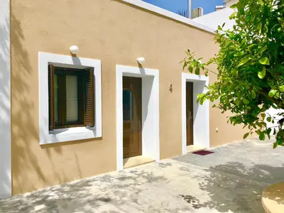 a building with three windows and a door at Bekos traditional house in Archangelos