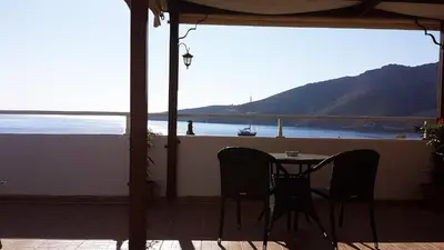 a table and chairs on a balcony with a view of the ocean at Apollo Studios in Livadia