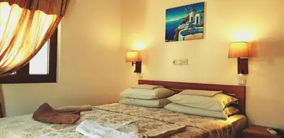 a bedroom with a bed with two pillows on it at Apollo Studios in Livadia