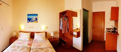 a small bedroom with two beds and a closet at Apollo Studios in Livadia