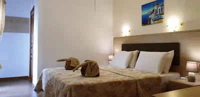 a bedroom with a bed with two stuffed animals on it at Apollo Studios in Livadia
