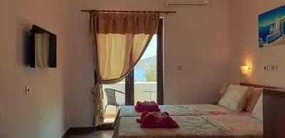 a hotel room with a bed and a large window at Apollo Studios in Livadia
