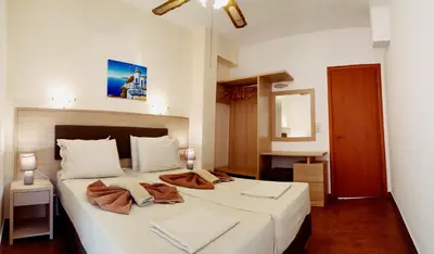 a bedroom with a large white bed with two pillows at Apollo Studios in Livadia