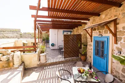 a patio with a blue door and a table and chairs at Galini Apartments Old Town in Rhodes Town