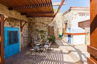 a patio with a blue door and a table and chairs at Galini Apartments Old Town in Rhodes Town