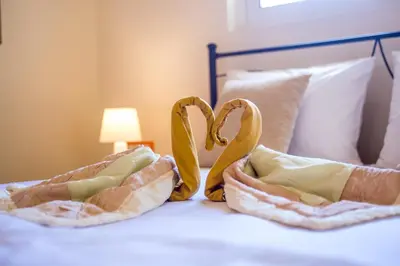 a bed with two hearts shaped pillows on it at MeFoMi Villa in Rhodes Town