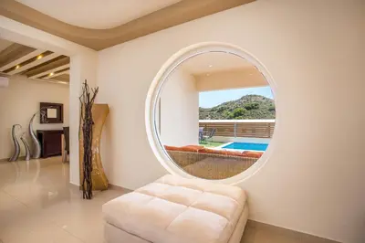 a round mirror in a living room with a couch at MeFoMi Villa in Rhodes Town
