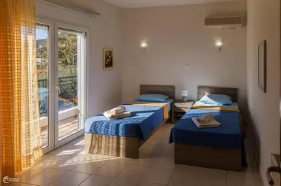 two beds in a room with a window at Villa Epavlis Haraki in Haraki