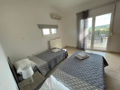 two beds in a room with a window at Villa Epavlis Haraki in Haraki