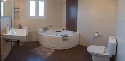 a bathroom with a tub and a toilet and a sink at Villa Epavlis Haraki in Haraki
