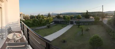 a balcony with a table and chairs and a garden at Villa Epavlis Haraki in Haraki
