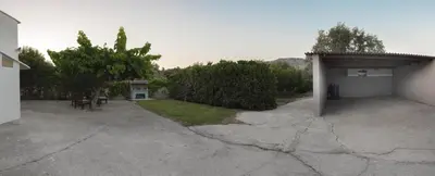 a parking lot of a building with a table and chairs at Villa Epavlis Haraki in Haraki