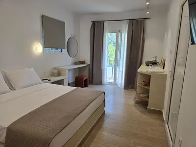 a bedroom with a bed and a desk and a window at Pension Zoi in Kolimbia