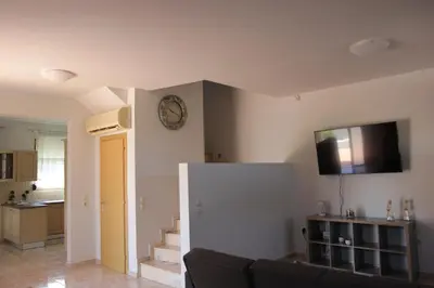 a living room with a couch and a clock on the wall at Platoni Elite Villas in Ialyssos