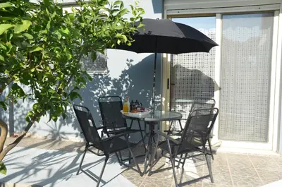 a table and chairs with an umbrella on a patio at Platoni Elite Villas in Ialyssos