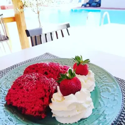 a red velvet cake with strawberries on a blue plate at Platoni Elite Villas in Ialyssos