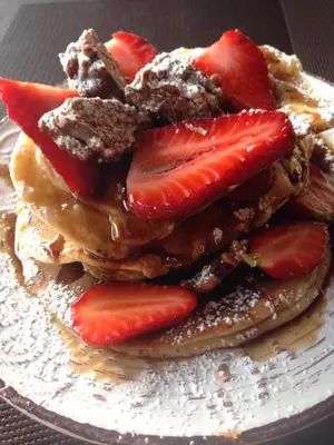 a stack of pancakes with strawberries on a plate at Platoni Elite Villas in Ialyssos