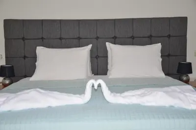 a large bed with white pillows and a headboard at Platoni Elite Villas in Ialyssos
