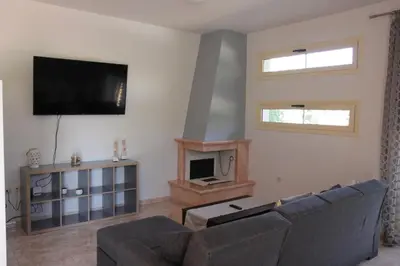 a living room with a couch and a flat screen tv at Platoni Elite Villas in Ialyssos
