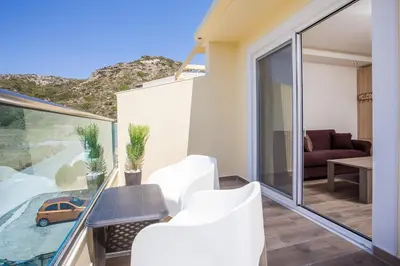 a room with a balcony with a table and chairs at Billy's Studios in Faliraki