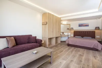 a living room with a couch and a bed at Billy's Studios in Faliraki
