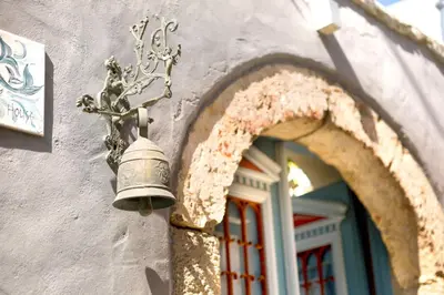 a bell on the side of a building with a window at Villa Ricolas in Symi