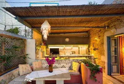 an outdoor patio with a table and a kitchen at Villa Ricolas in Symi