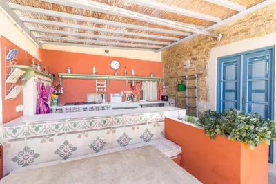 a kitchen with orange and white walls and a counter at Villa Ricolas in Symi