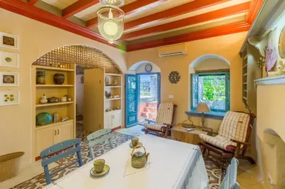 a living room with a white table and chairs at Villa Ricolas in Symi
