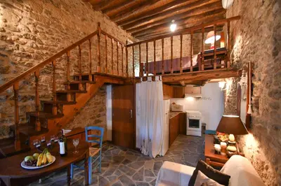 a room with a staircase and a table and a kitchen at Stone house in Rhodes Town
