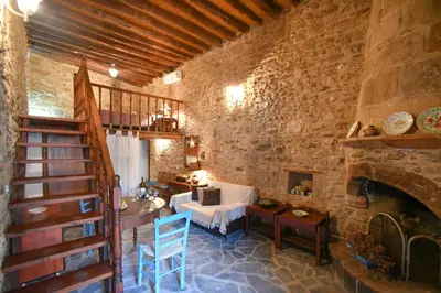 a living room with a staircase and a stone wall at Stone house in Rhodes Town