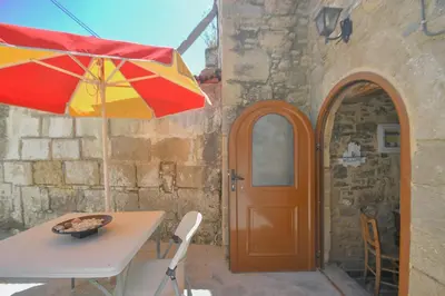 a table and an umbrella next to a building at Stone house in Rhodes Town