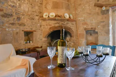 a bottle of wine sitting on a table with glasses at Stone house in Rhodes Town