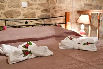a bed with white towels and flowers on it at Stone house in Rhodes Town