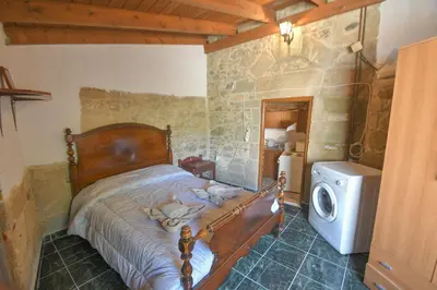 a bedroom with a bed and a washing machine at Stone house in Rhodes Town