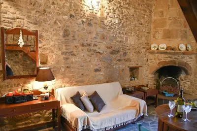a living room with a couch and a stone wall at Stone house in Rhodes Town