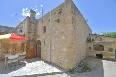 a stone building with a table and an umbrella at Stone house in Rhodes Town
