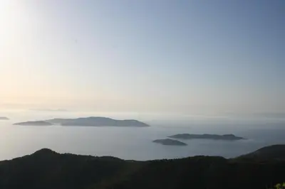 a view of the ocean with mountains in the distance at Ataviros Hotel in Émbonas