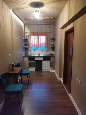 a kitchen with a table and blue chairs in a room at Ataviros Hotel in Émbonas