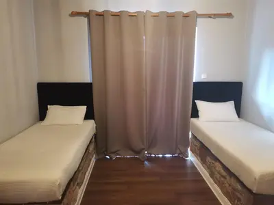two beds in a room with a curtain at Ataviros Hotel in Émbonas