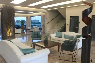 a living room with white furniture and a staircase at Vallian Village Hotel in Paradeísion