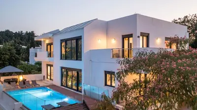 a house with a swimming pool in front of it at Villa Melia in Koskinou