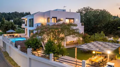 a house with a swimming pool in front of it at Villa Melia in Koskinou