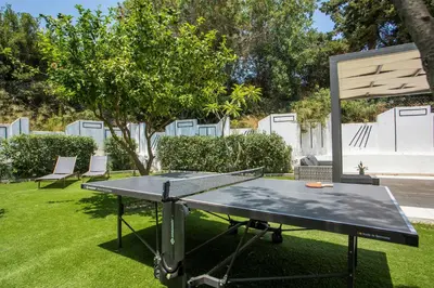 a ping pong table in a yard with a table at Villa Melia in Koskinou