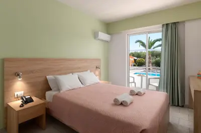 a hotel room with a bed with towels on it at Meliton Hotel in Theologos