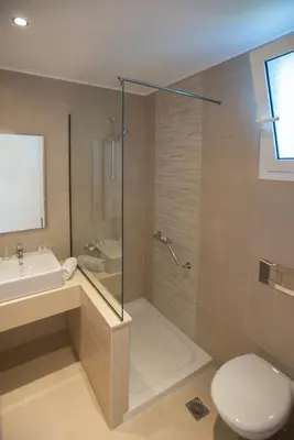 a bathroom with a shower and a toilet and a sink at Meliton Hotel in Theologos
