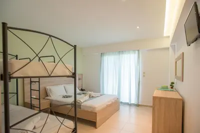 a bedroom with two bunk beds and a window at Meliton Hotel in Theologos