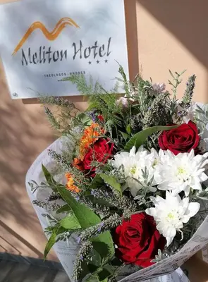 a bouquet of red and white flowers and a sign at Meliton Hotel in Theologos
